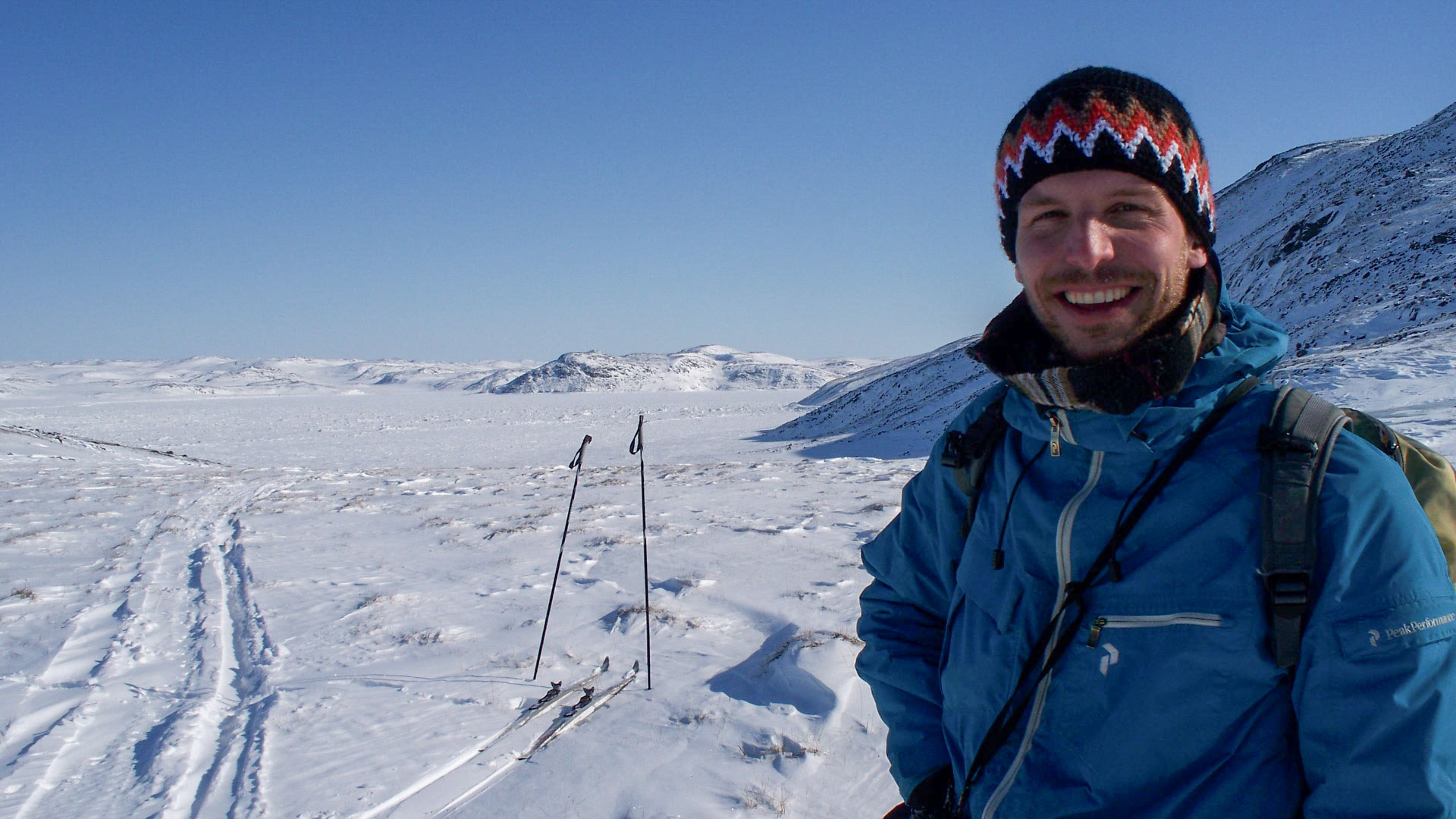 Smiling man in snowy landscape.