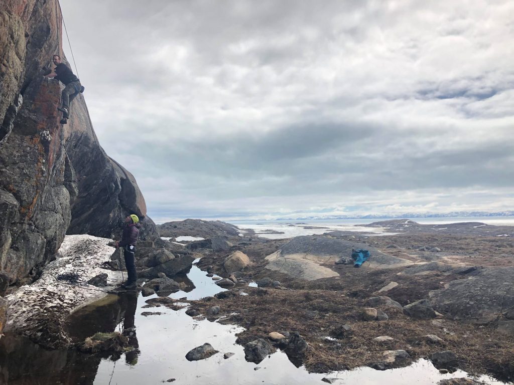 Climbers on rocky landscape near water