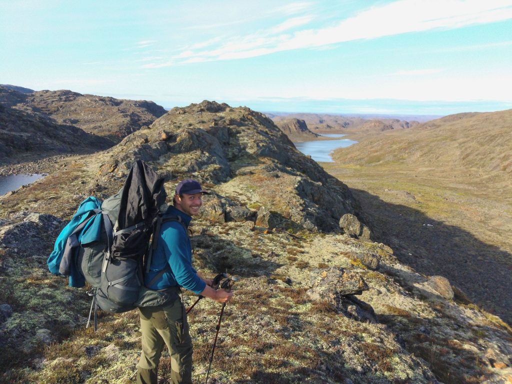 Hiker on rocky terrain, scenic view.