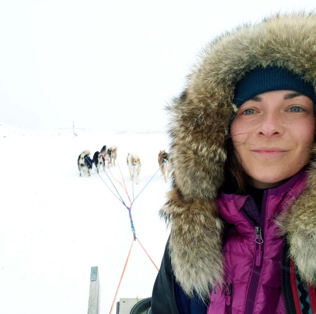 Woman with sled dogs in snow