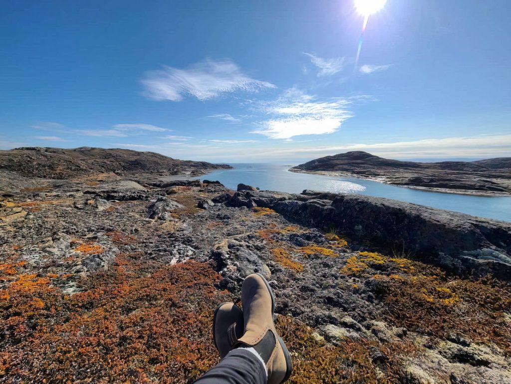 Person relaxing by serene landscape