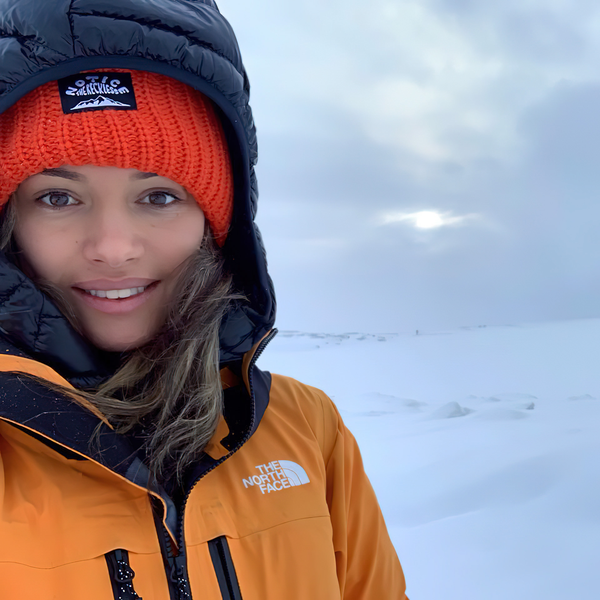 Person smiling in snowy landscape.