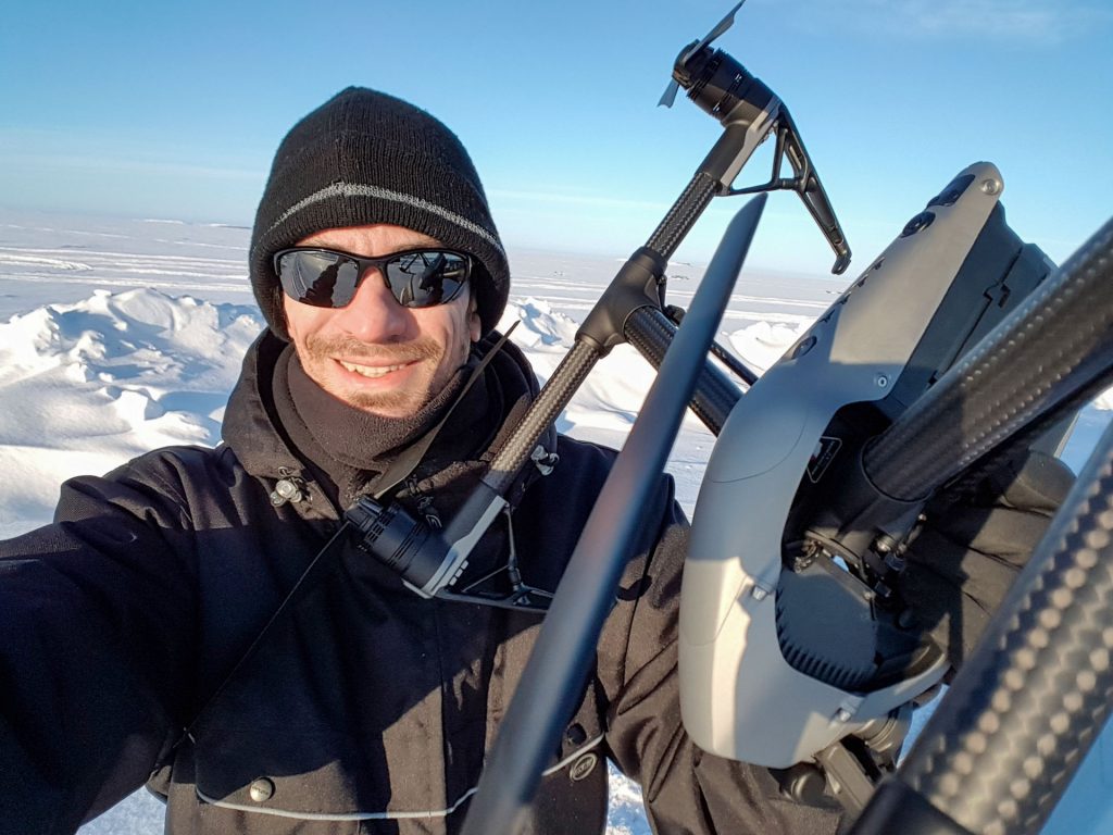 Man holding drone in snowy landscape
