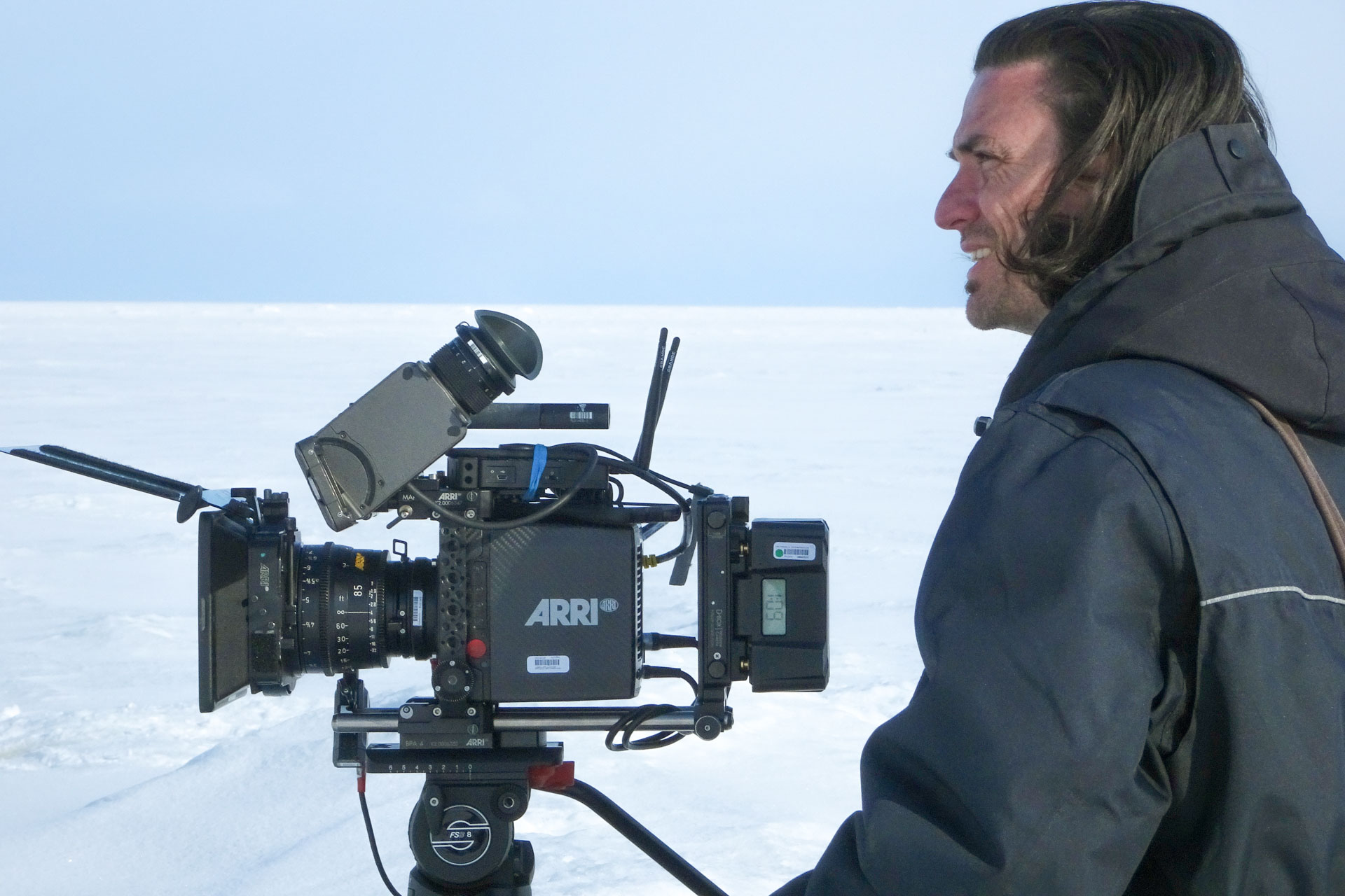 Filmmaker operating camera in snow
