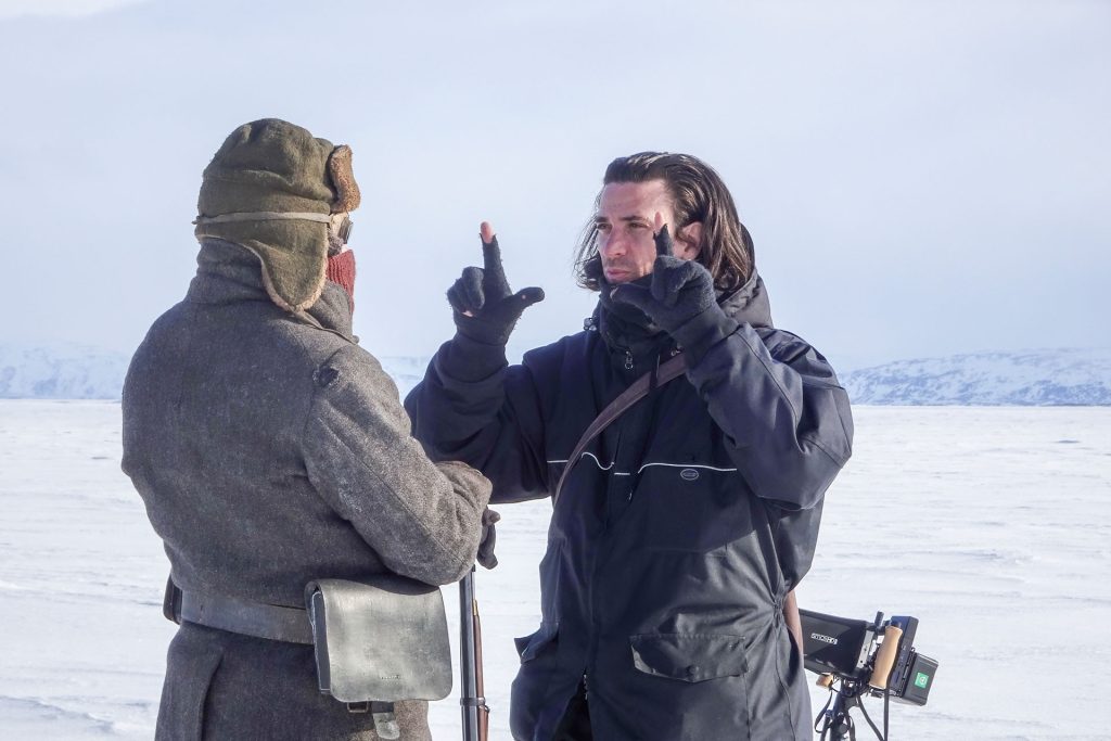 Two men discussing in snowy landscape.