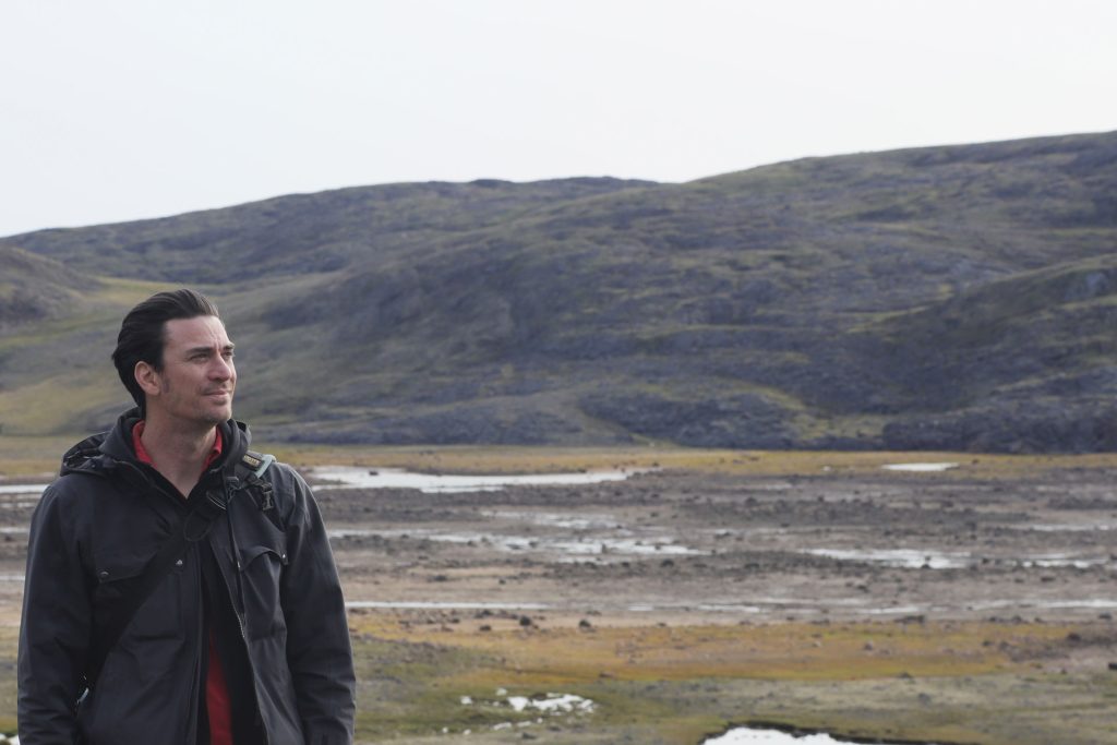Man standing in a rugged landscape.