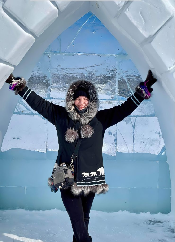 Person in winter attire inside igloo
