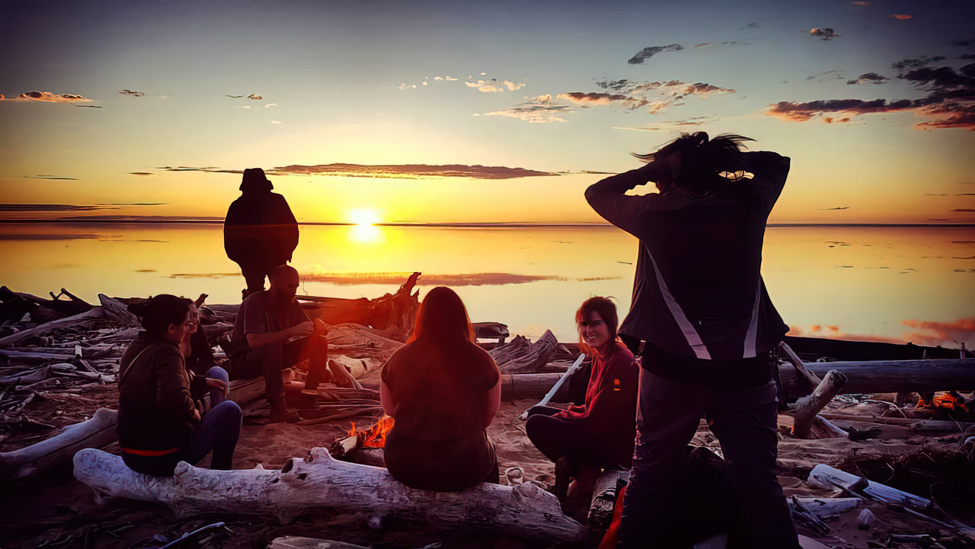 Group by fire at sunset beach