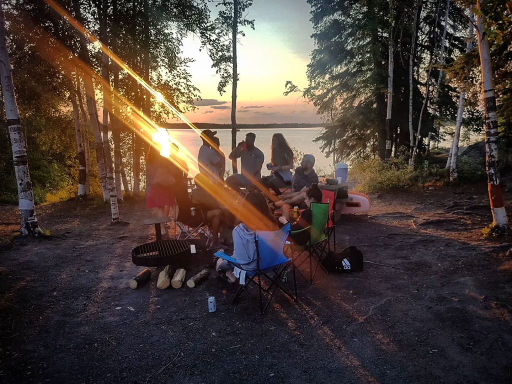 Group gathering by the lakeside sunset