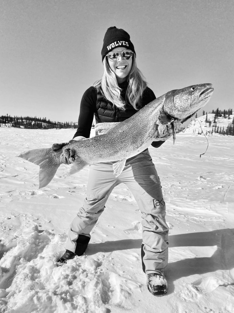 Woman holding large fish outdoors