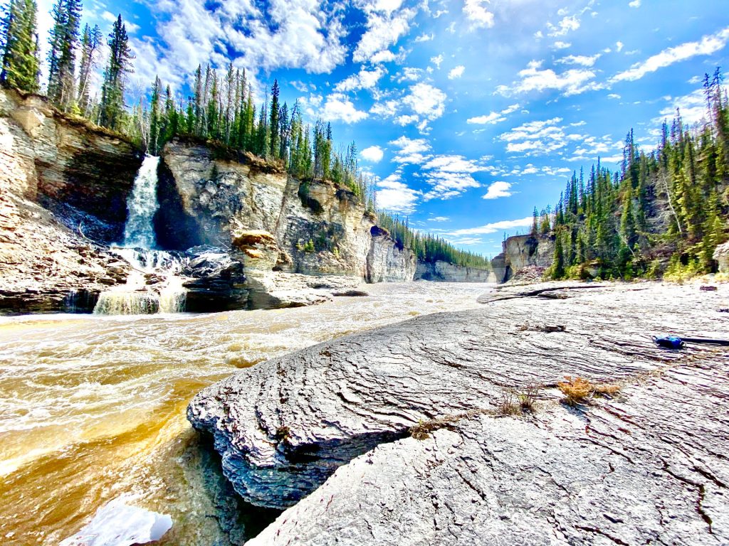 Waterfall in rocky, forested landscape