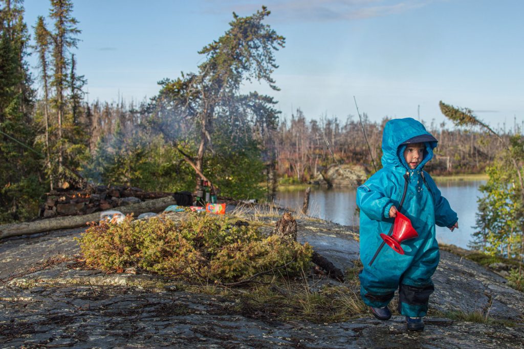 Child in blue coat near water