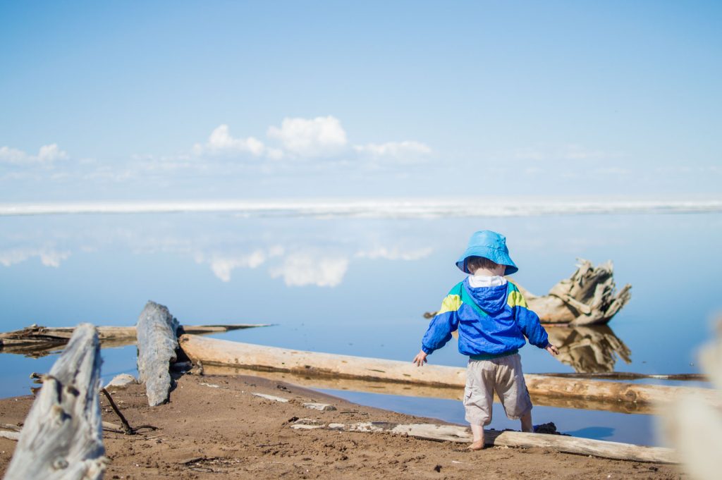 Child exploring a serene beach scene.