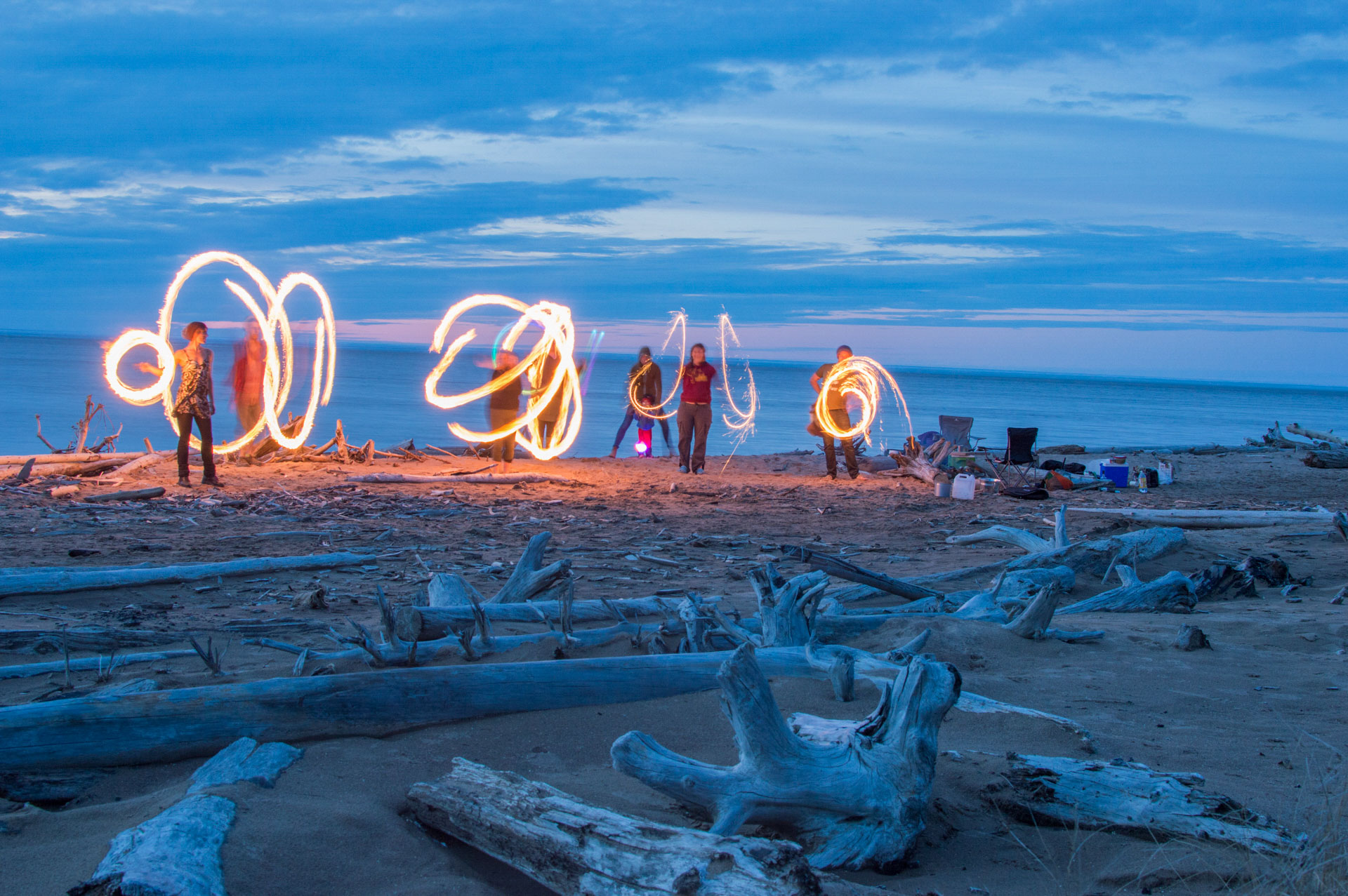 People creating light trails on beach