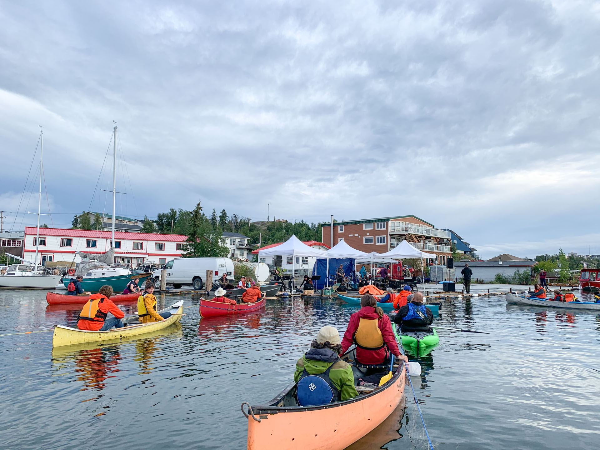Kayakers gathering near waterfront buildings.