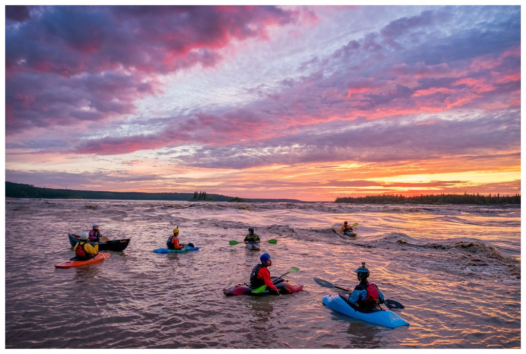 Kayakers on river at sunset