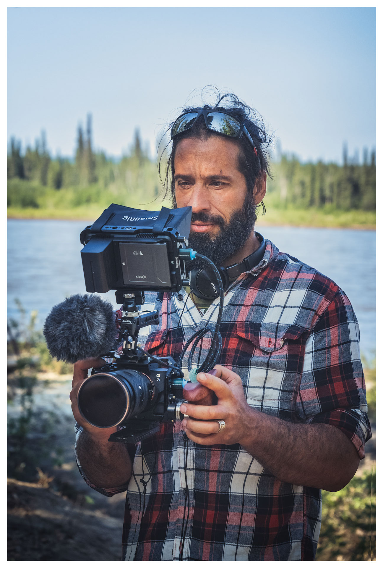 Man filming by the riverbank.