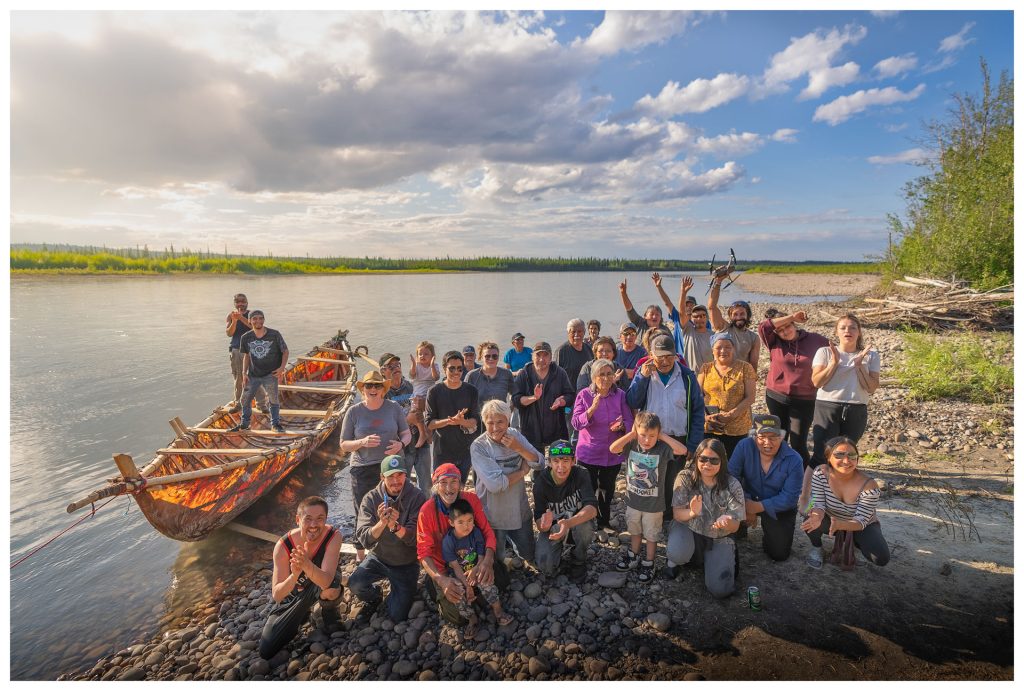 Group of people by riverbank.
