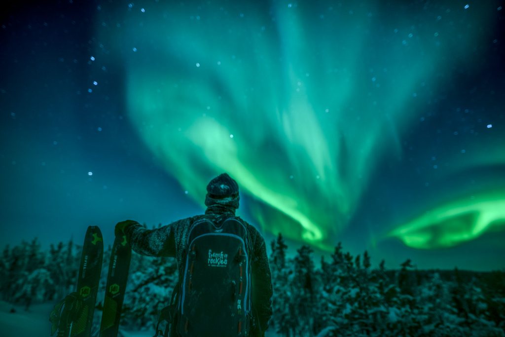 Person skiing under northern lights
