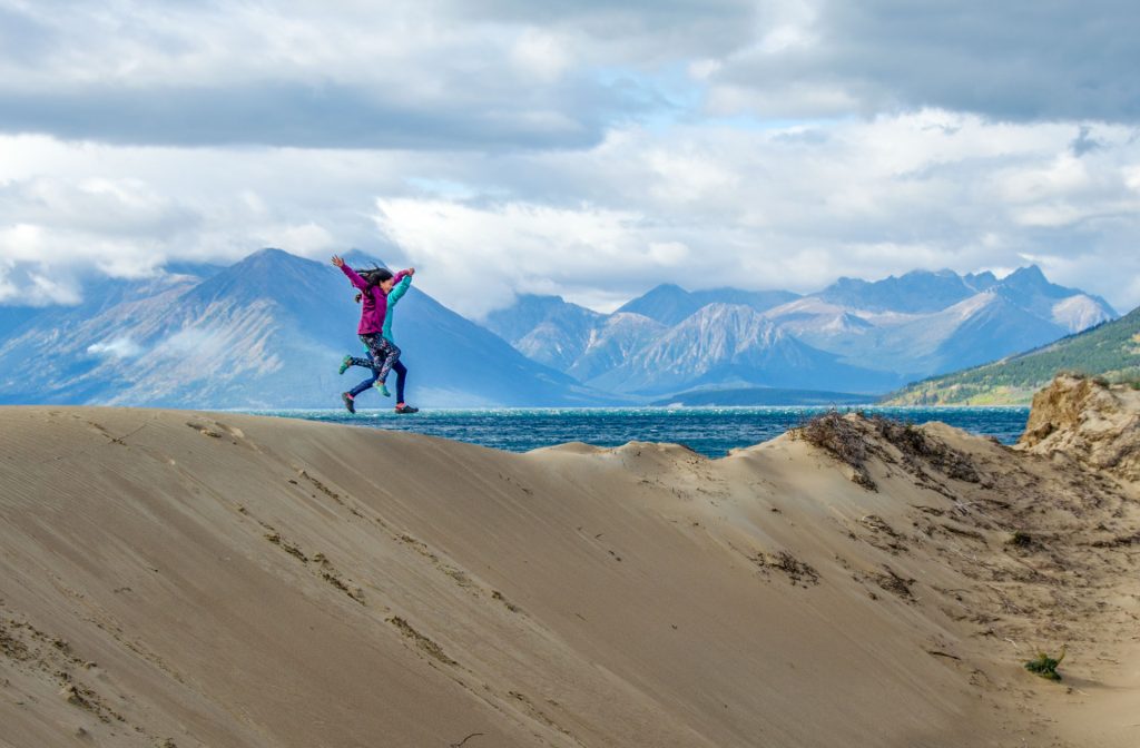 Person jumping on sandy landscape