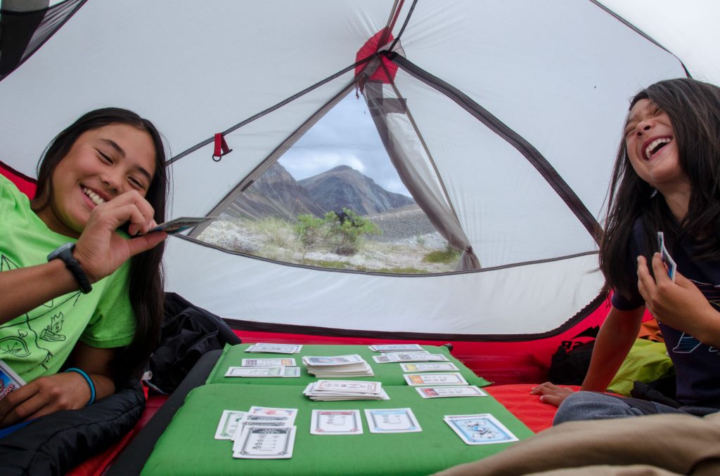 Two kids playing cards in tent
