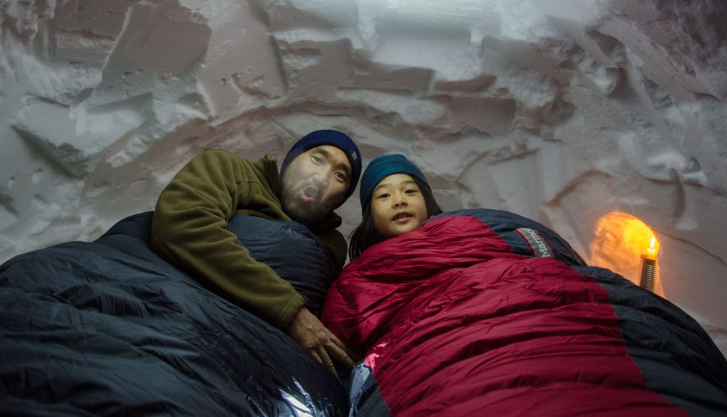 Two people inside an igloo.