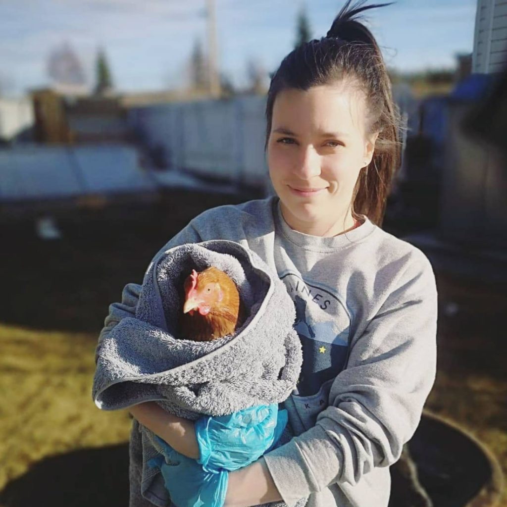 Woman holding a chicken wrapped in towel