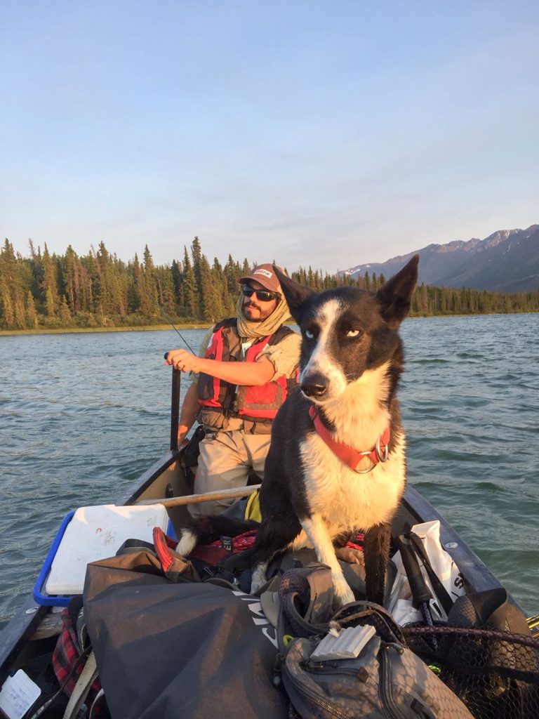 Man and dog in canoe on water
