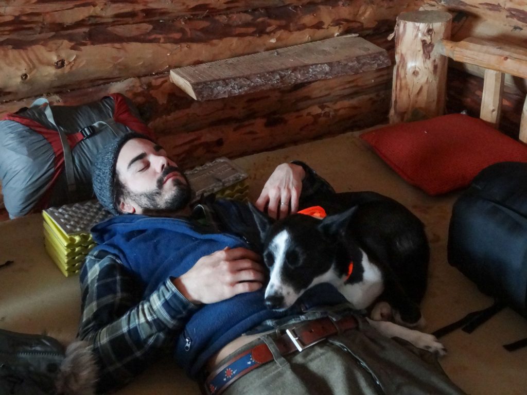 Man resting with dog indoors.