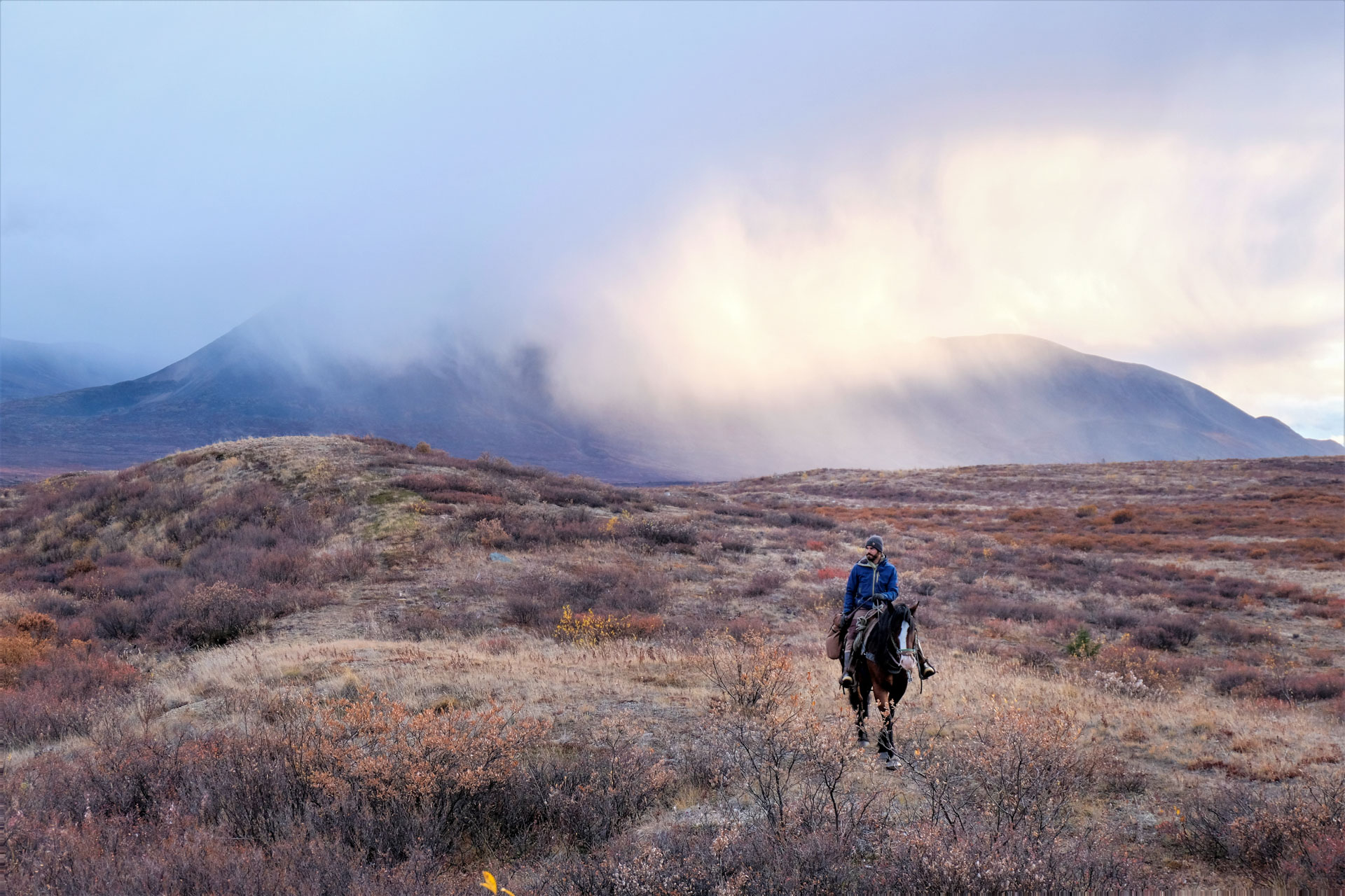Person riding horse in vast landscape