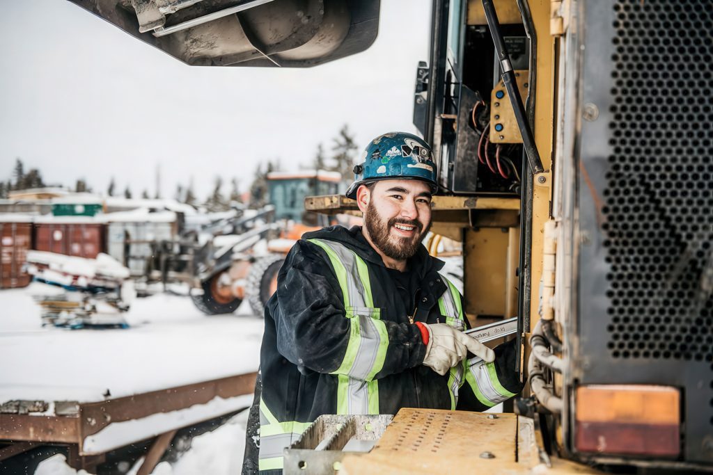 Worker repairing machinery in winter