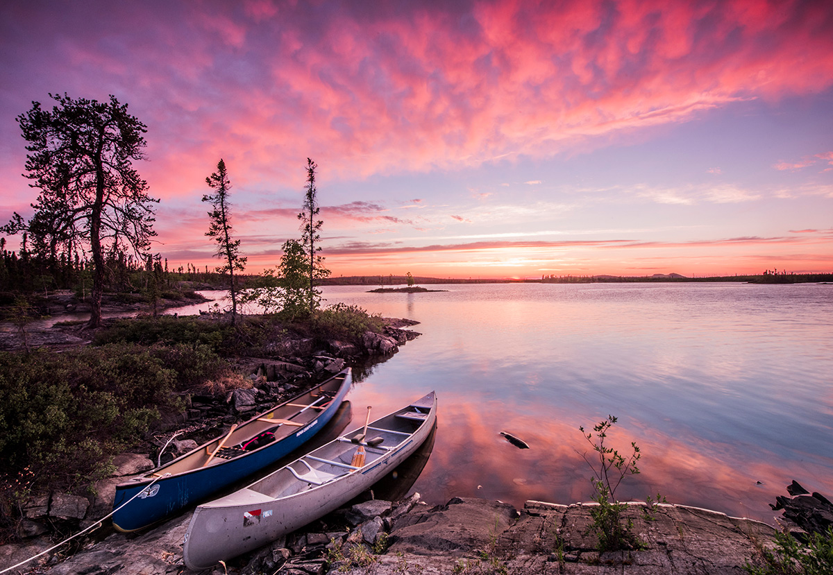 Canoes by serene sunset lake