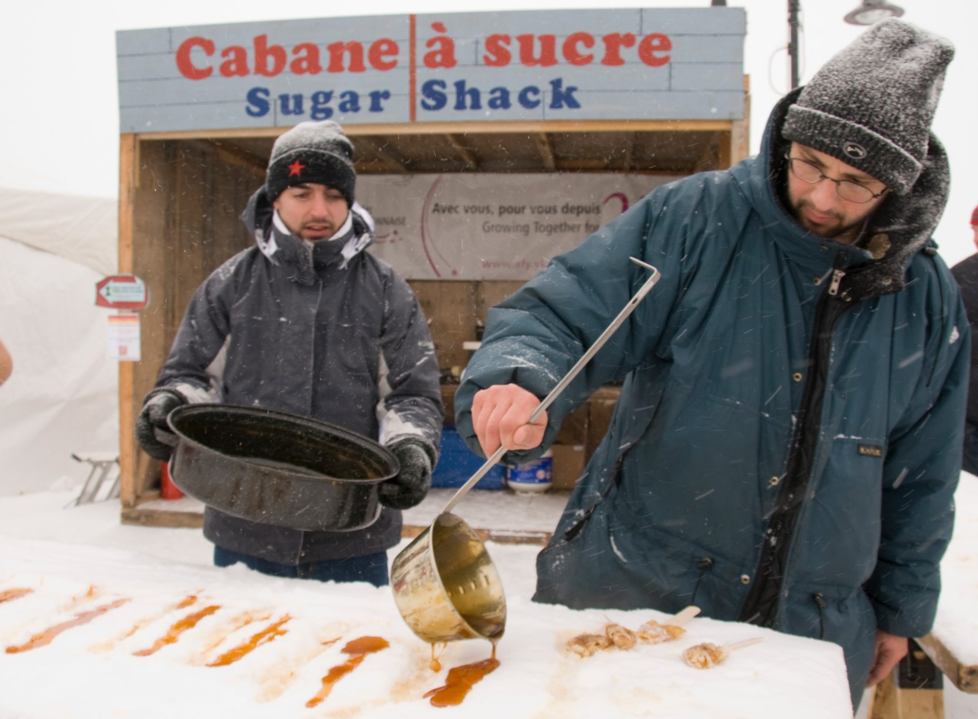 Men preparing maple syrup outdoors